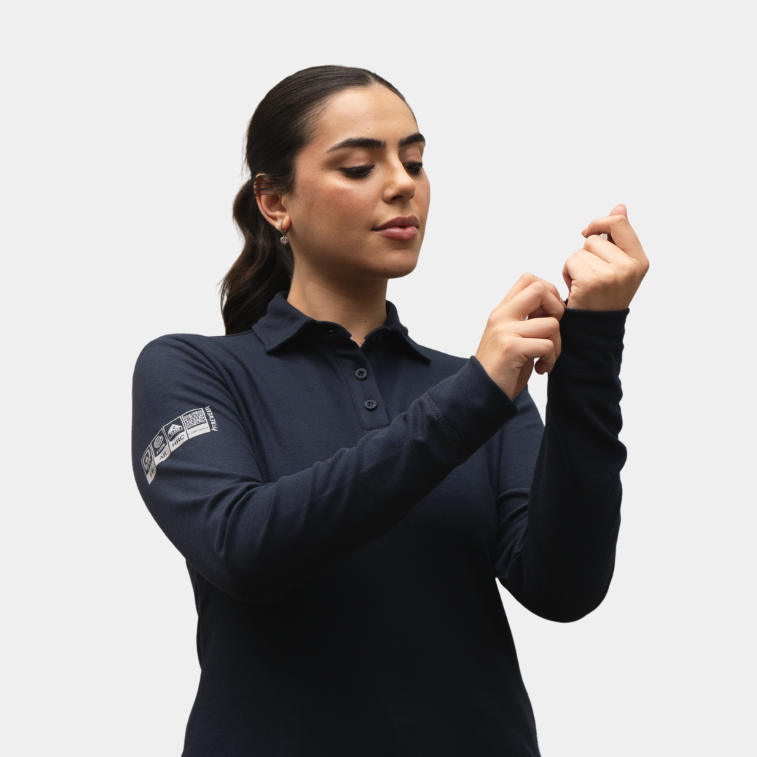 Detalle de puño y manga de polera polo ignífuga FIREWEAR® azul marino para mujer.